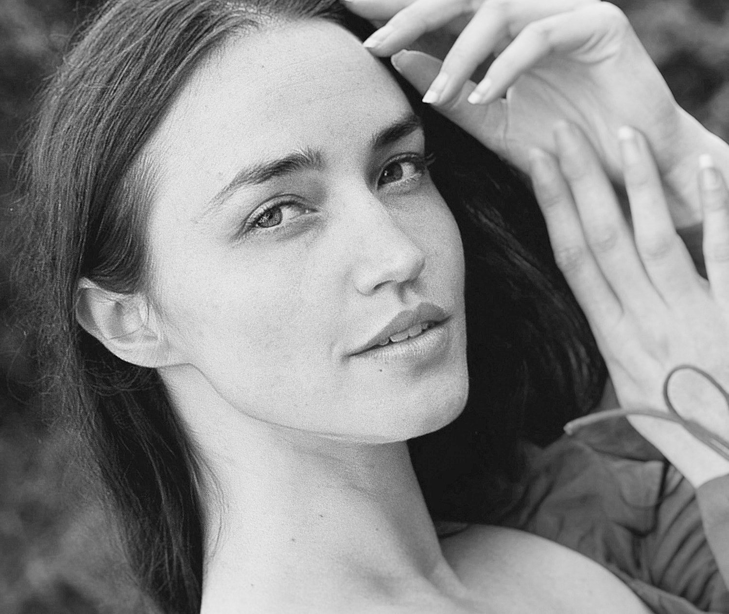 Woman touching her face with soft expression.