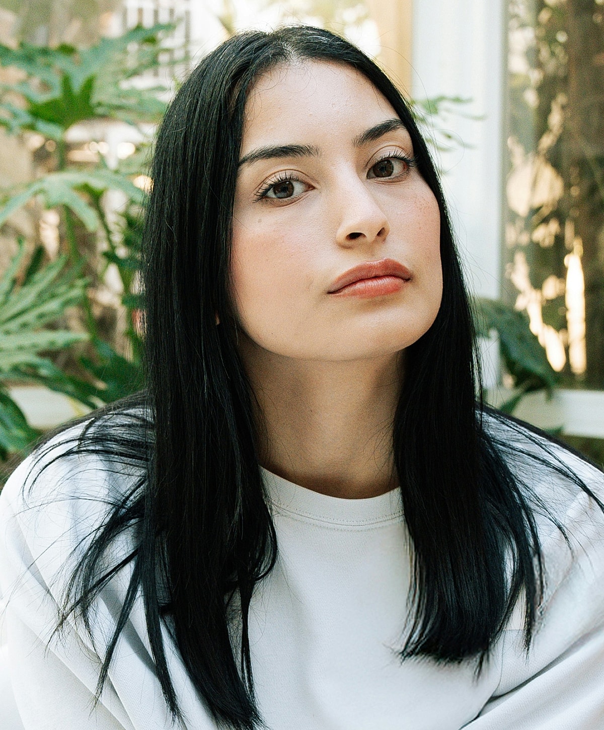 Woman with long dark hair in natural setting.