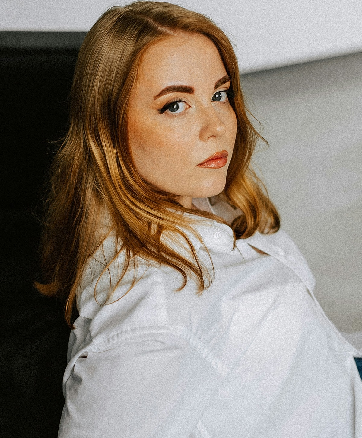 Woman with long hair in white shirt portrait.