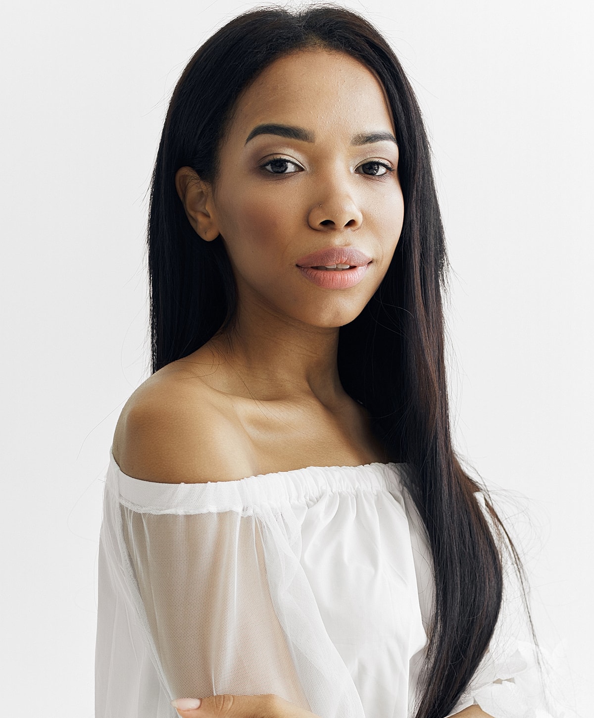Woman in off-shoulder blouse against white background.