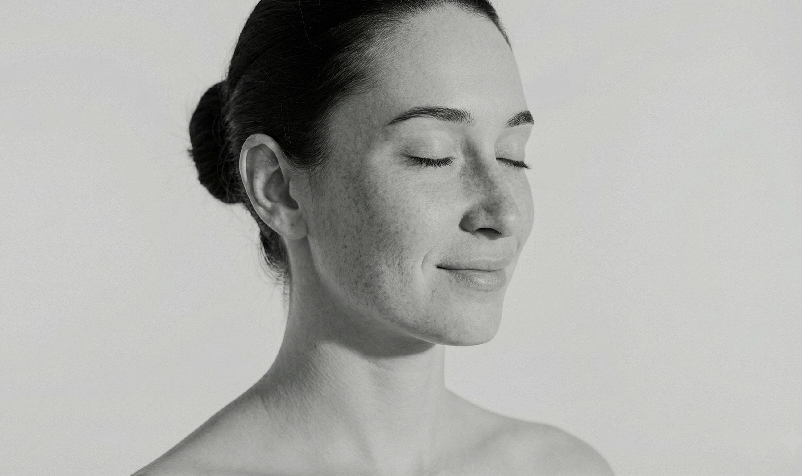 Woman with closed eyes, serene expression, black and white.
